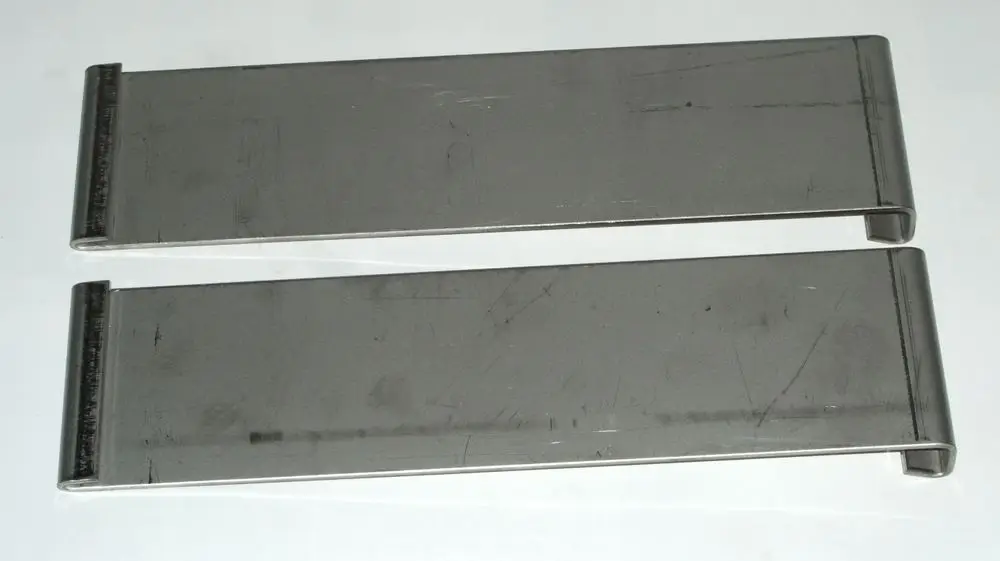 Zwei metallene Clips in länglicher Form, die möglicherweise als Zubehör für ein Daikin Produkt dienen. Sie sind einfach und ohne zusätzliche Merkmale gestaltet.